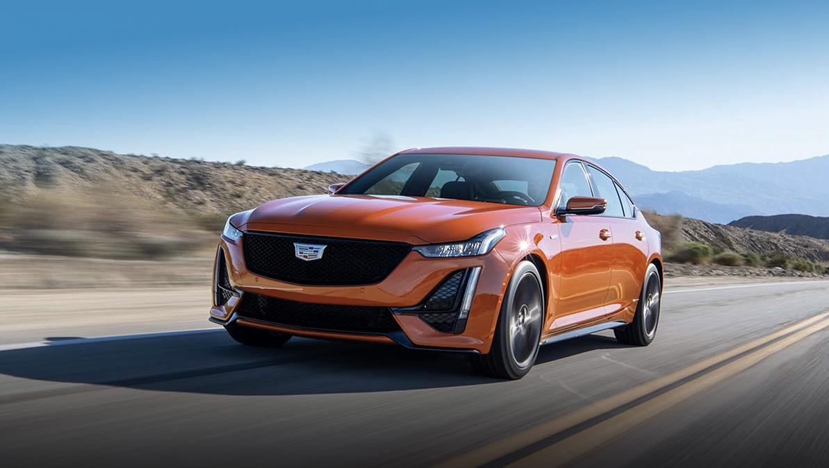 An orange 2022 Cadillac CT5-5 driving on a remote highway.