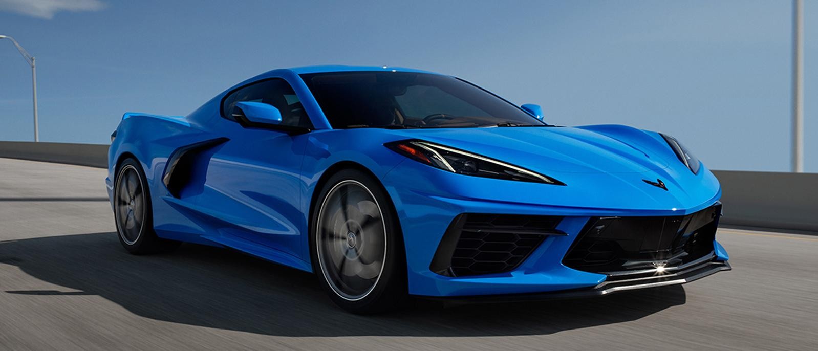 A blue Chevy Corvette cruising along a highway.