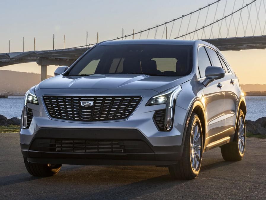 Front shot of gray XT4 in front of bridge at sunset