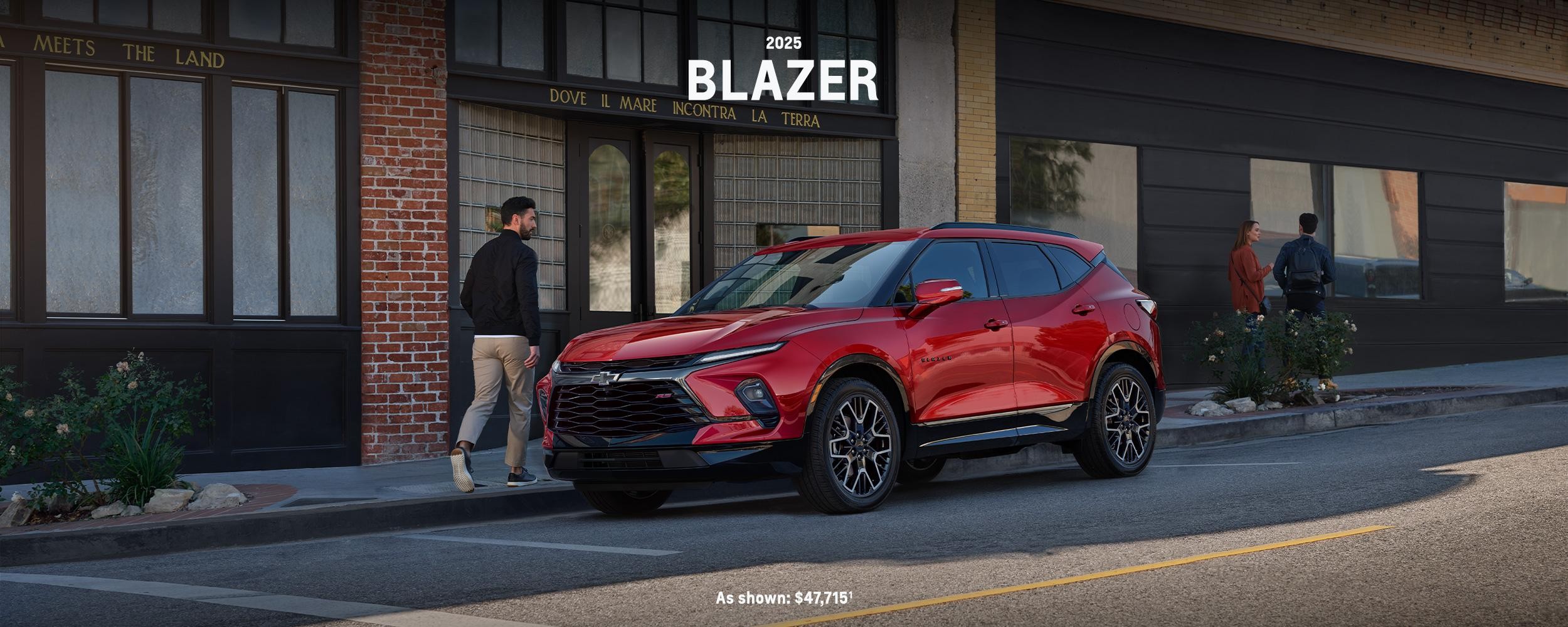 Red 2025 Blazer parked by a sidewalk in a city