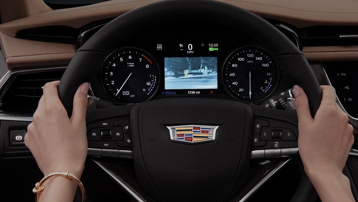 Women holding an XT6 steering wheel