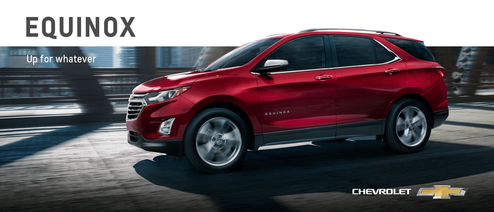 A red Chevy Equinox driving on a bridge.