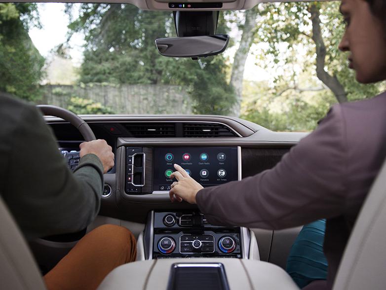 man driving gmc and woman using in vehicle app man driving gmc and woman using in vehicle app