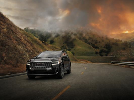 Black GMC driving away from fire in mountains Black GMC driving away from fire in mountains