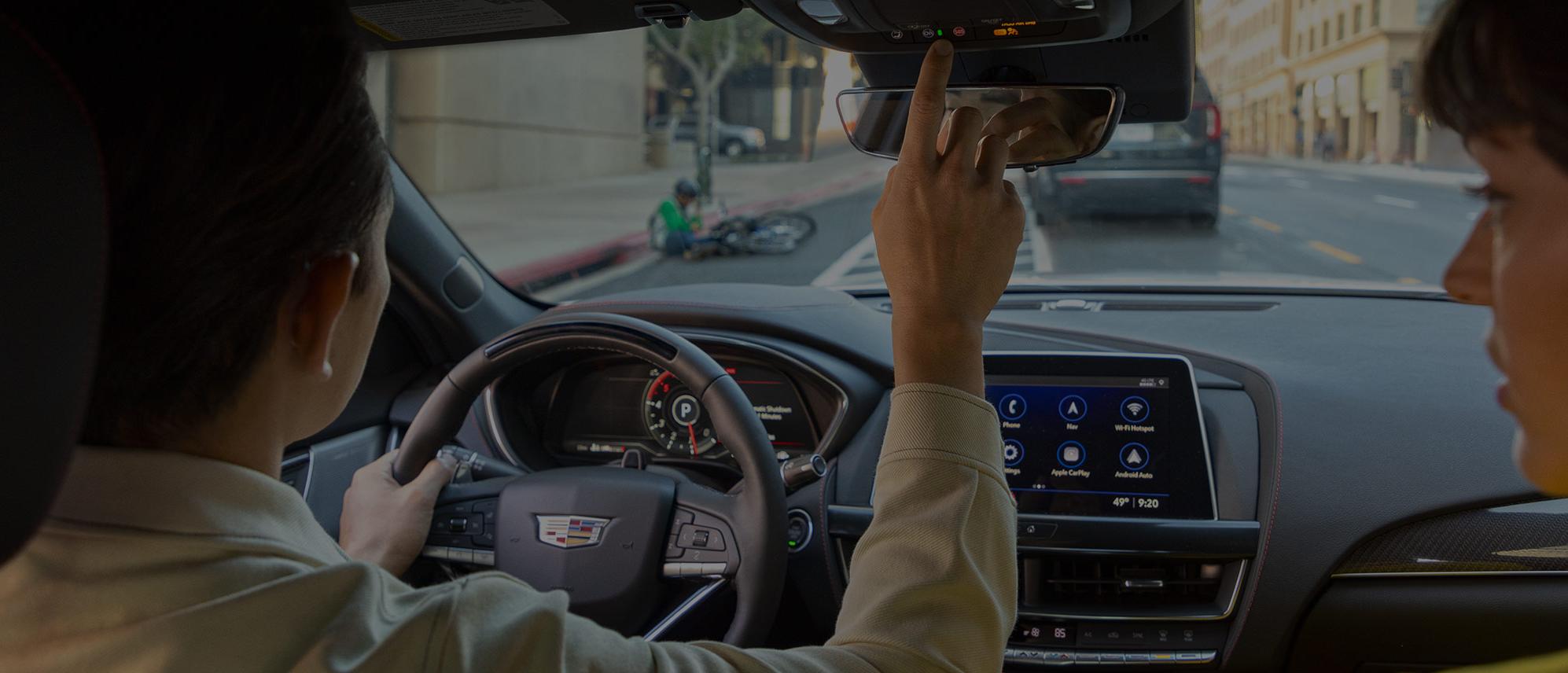 Woman holding steering wheel in cadillac vehicle Woman holding steering wheel in cadillac vehicle