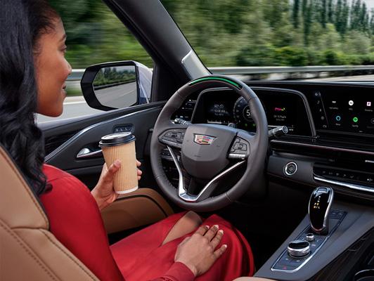 Woman holding coffee and not using the steering wheel Woman holding coffee and not using the steering wheel