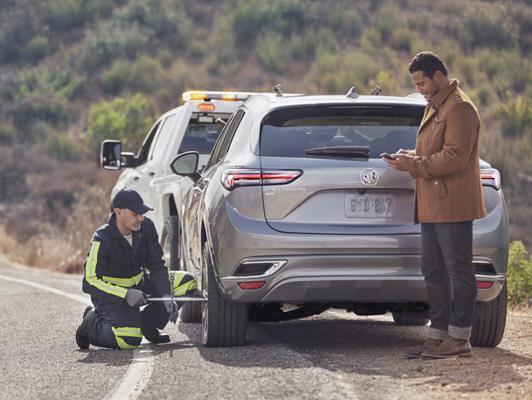Someone fixing Buick tire on side of road Someone fixing Buick tire on side of road