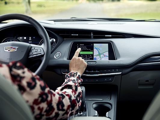 Woman touching screen on cadillac 