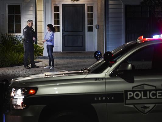 Police Officer talking to woman outside home