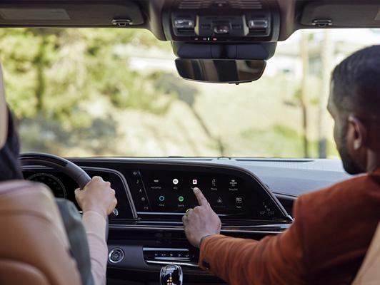 Man touching app screen on cadillac