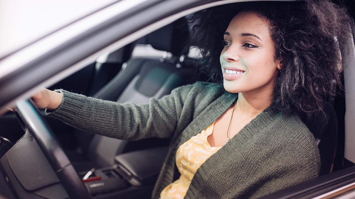 A young woman in the driver's seat of a vehicle. A young woman in the driver's seat of a vehicle.