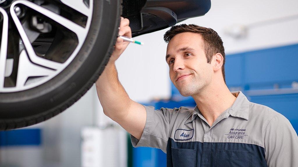 Service tech checking tire tread