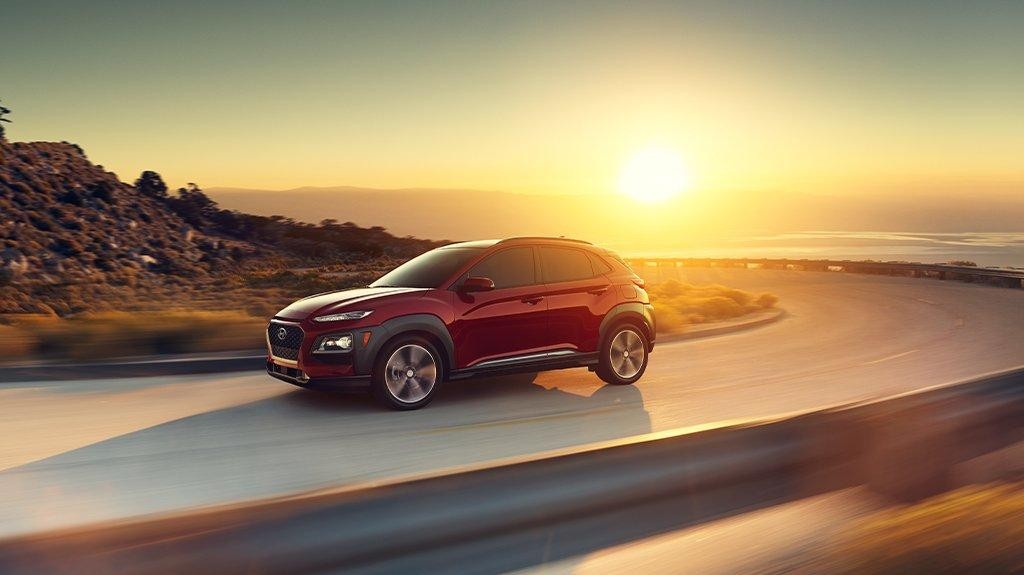 Hyundai vehicle driving on a seaside higway at sunset