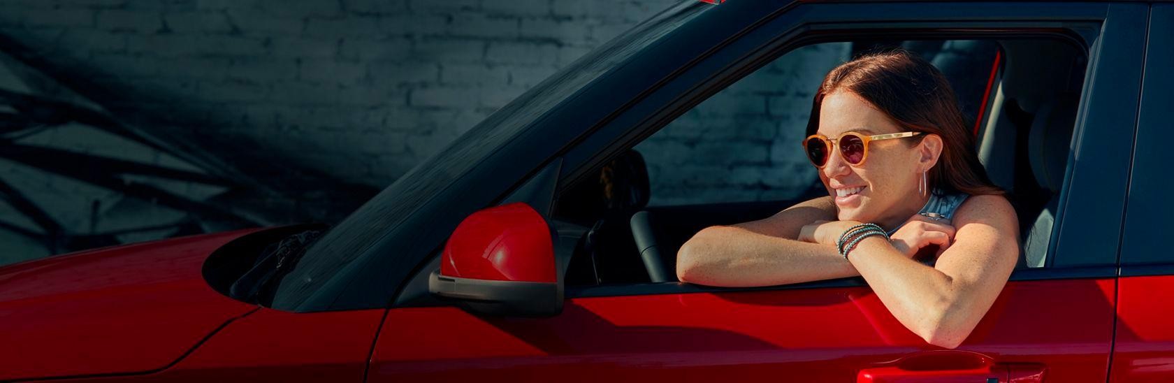 A girl sitting in a car in a window seat 