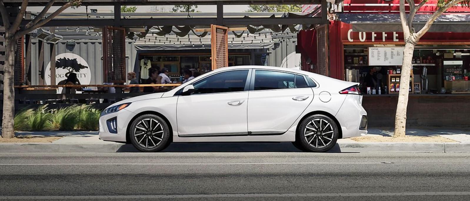 A white Hyundai Ioniq Electric parked on sidewalk