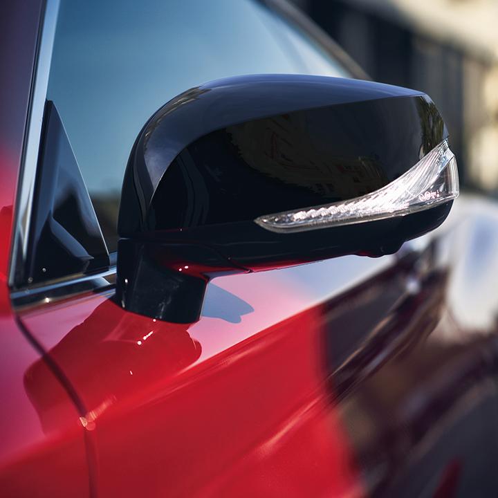 Close-up view of the side mirror on a red INFINITI Q60. Close-up view of the side mirror on a red INFINITI Q60.