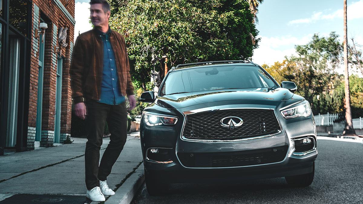 A man stepping into the street in front of a parked INFINITI QX60. A man stepping into the street in front of a parked INFINITI QX60.