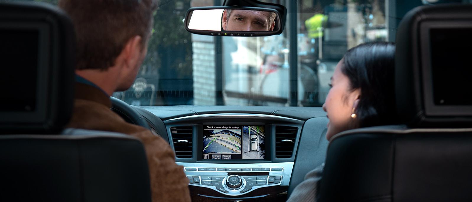 A couple in their INFINITI QX60 with the Around View feature engaged on the touchscreen. A couple in their INFINITI QX60 with the Around View feature engaged on the touchscreen.