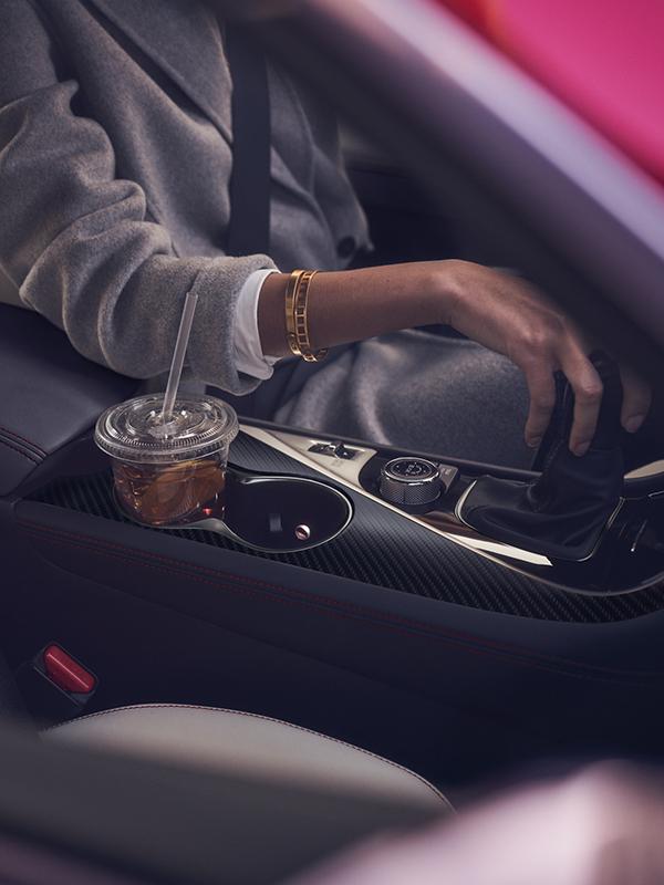 Interior view of an INFINITI Q60 with a woman in the driver's seat. Interior view of an INFINITI Q60 with a woman in the driver's seat.