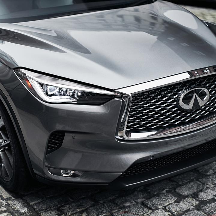 Close-up view of the headlight of a grey INFINITI QX50. Close-up view of the headlight of a grey INFINITI QX50.