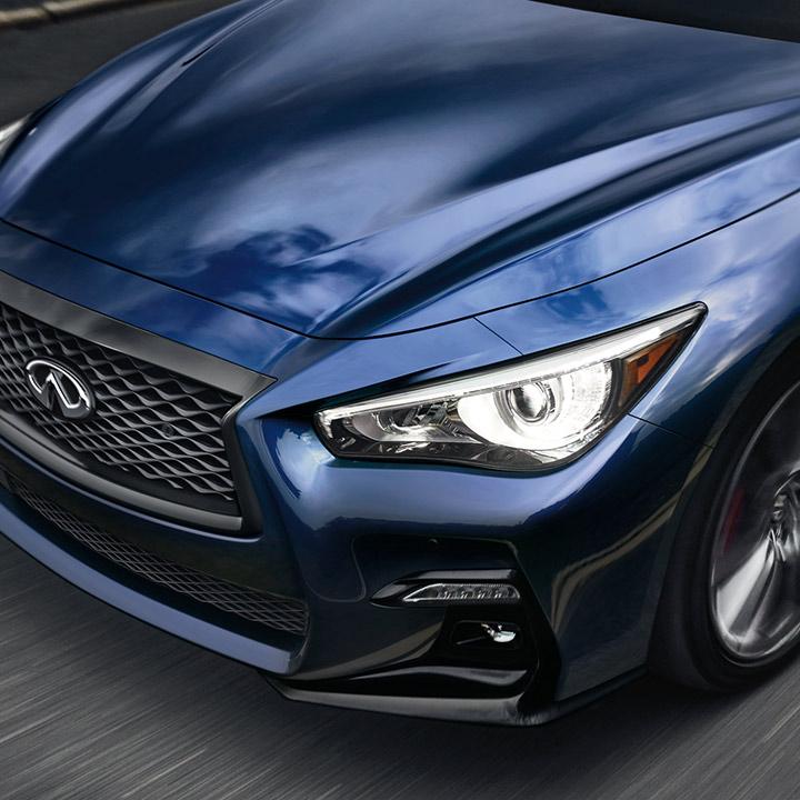 Close-up view of a blue INFINITI Q50 headlight. Close-up view of a blue INFINITI Q50 headlight.