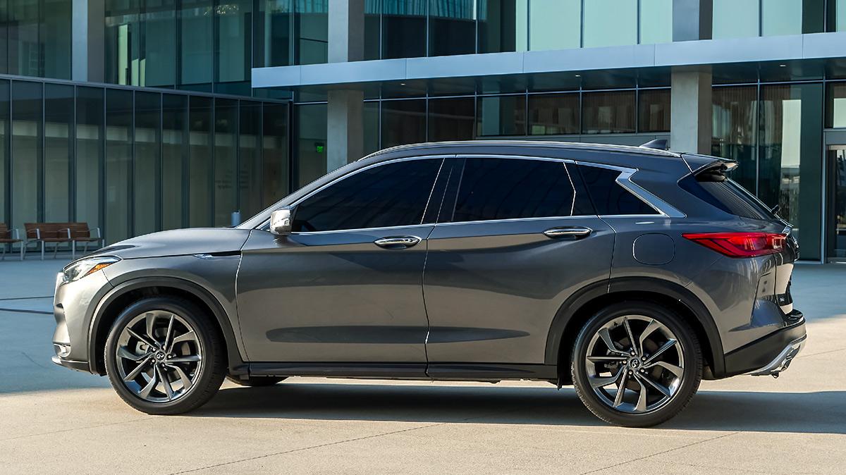 Profile view of a grey INFINITI QX50 parked in front of an office park. Profile view of a grey INFINITI QX50 parked in front of an office park.