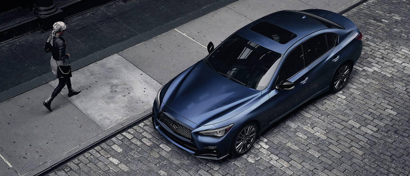 INFINITI Q50 Parked Outside on brick road with someone walking by INFINITI Q50 Parked Outside on brick road with someone walking by