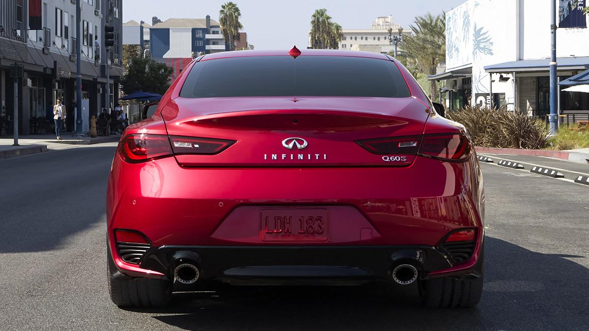 Rear view of a red INFINITI Q60 in the middle of a city street. Rear view of a red INFINITI Q60 in the middle of a city street.