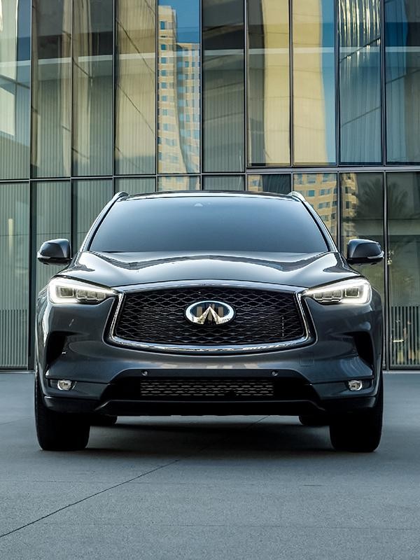 Head-on view of a grey INFINITI QX50 parked in front of an office building.