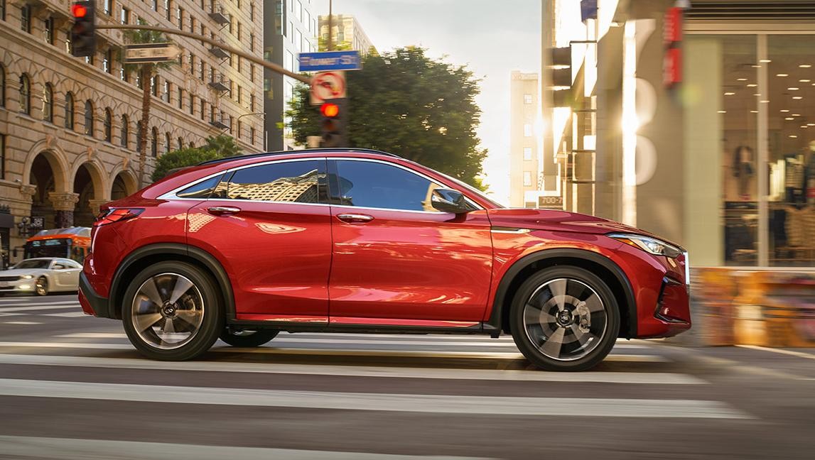 A red QX55 on city street.