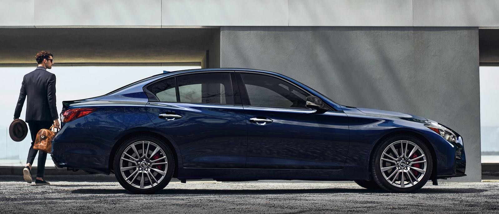 Profile view of an INFINITI Q50 parked at a modern home. Profile view of an INFINITI Q50 parked at a modern home.
