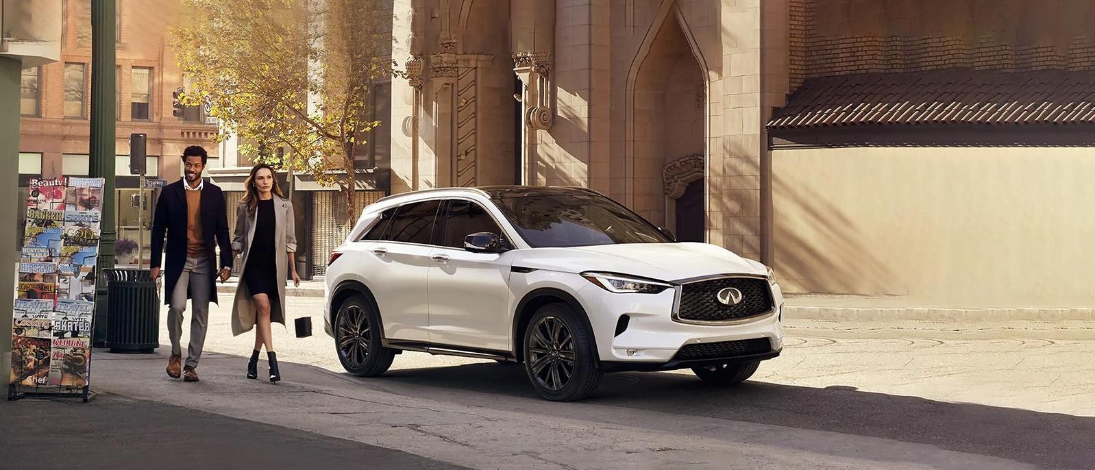 A White INFINITI QX50 Parked in front of a vintage Building. A White INFINITI QX50 Parked in front of a vintage Building.