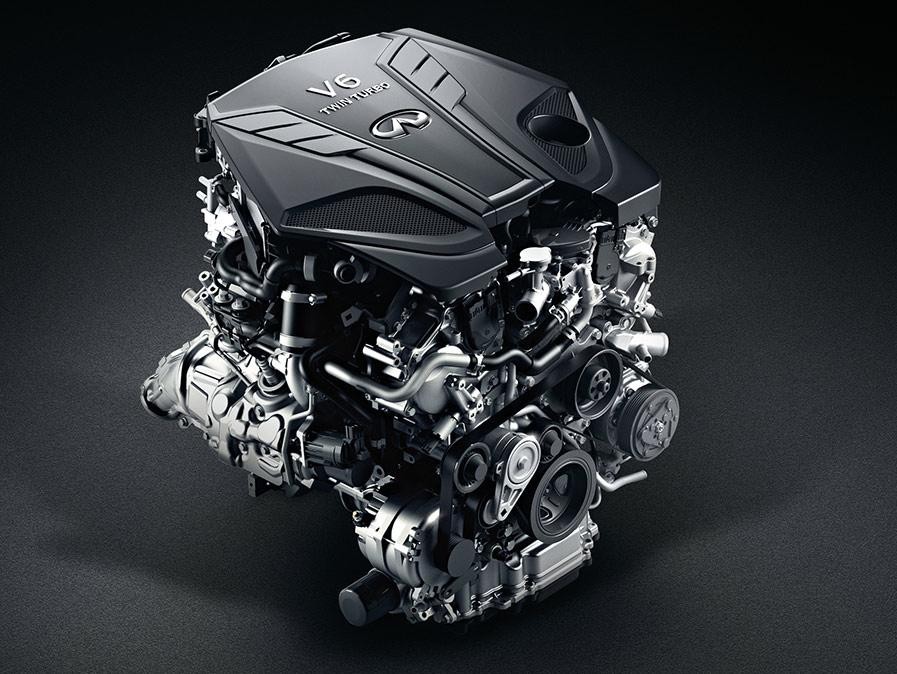 An INFINITI Q50 engine in a dark studio.