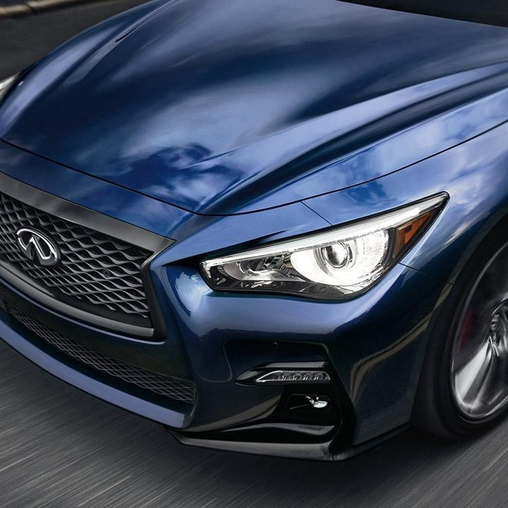 Close-up view of a blue INFINITI Q50 headlight. Close-up view of a blue INFINITI Q50 headlight.
