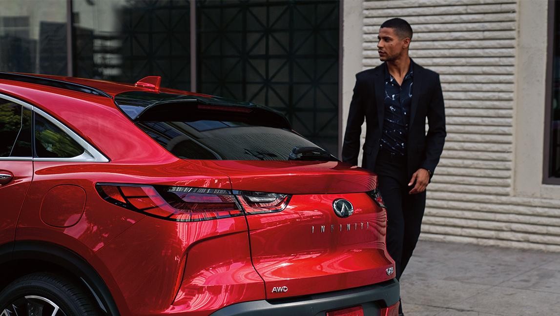 Back profile view of a red INFINITI QX55.