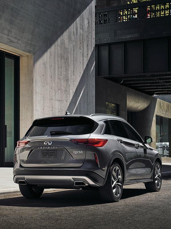 A grey INFINITI QX50 parked on a city street.