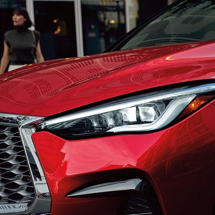 Close-up view of a red INFINITI QX55 headlight.