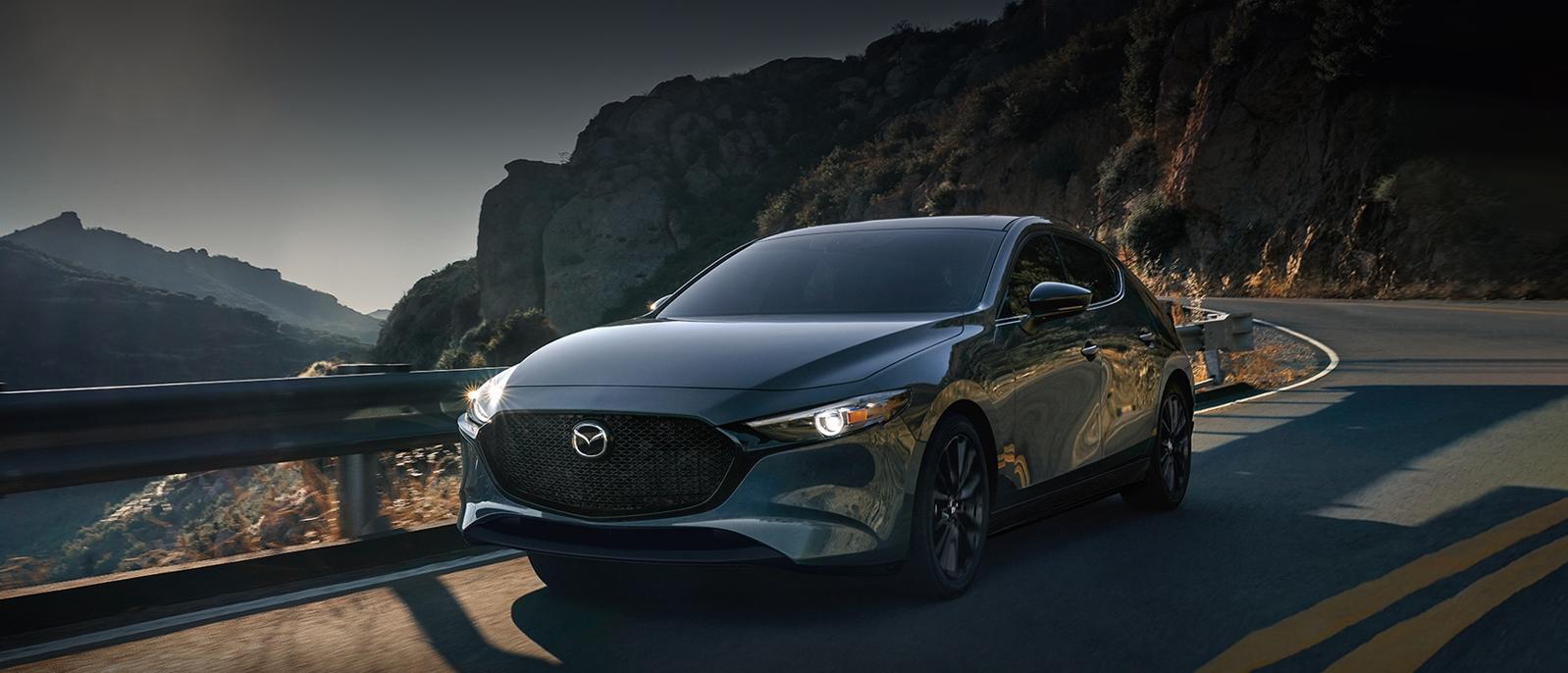 A 2022 Mazda3 Hatchback driving on the road. A 2022 Mazda3 Hatchback driving on the road.