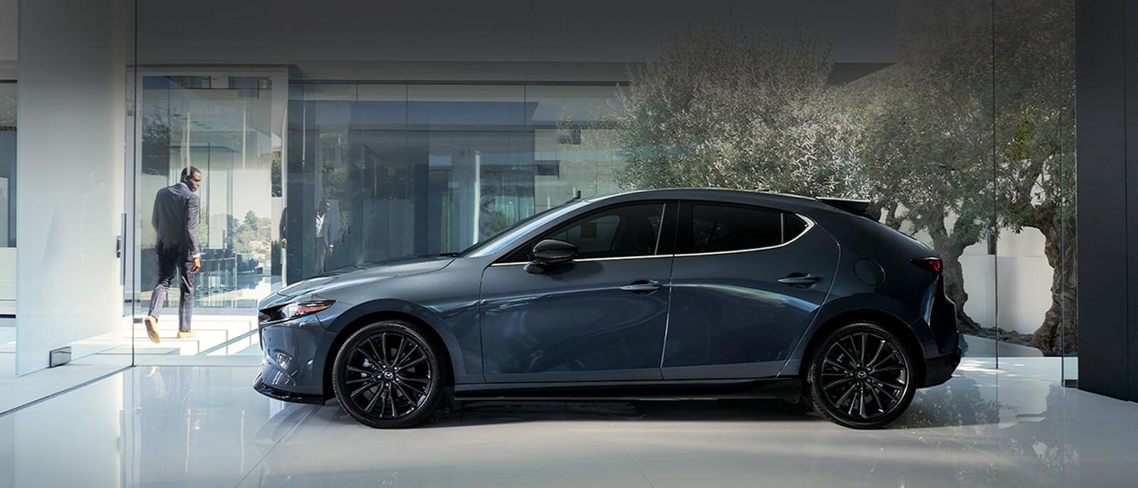 A 2020 Mazda3-Hatchback parked in a showroom. A 2020 Mazda3-Hatchback parked in a showroom.