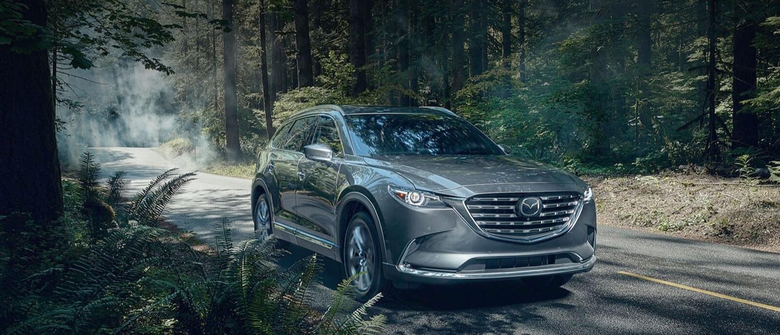 2021 Mazda CX-9 driving through woods. 2021 Mazda CX-9 driving through woods.