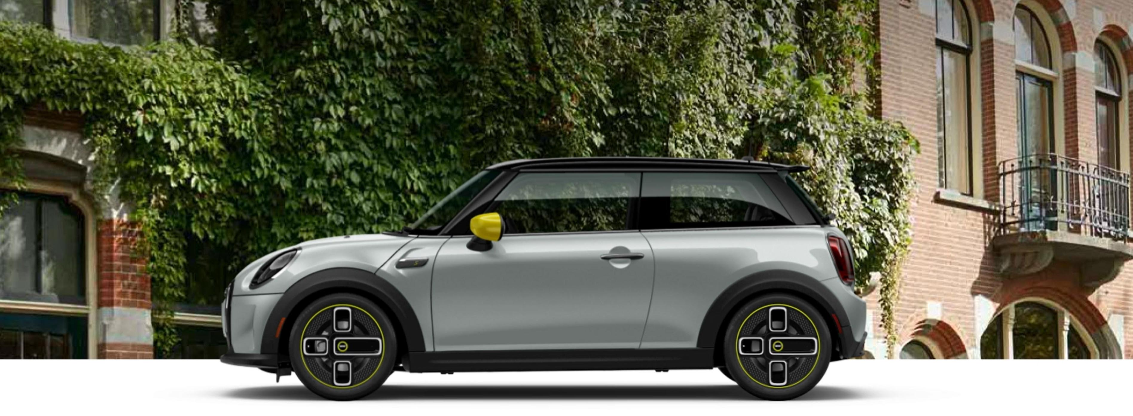 A 2022 MINI Cooper SE Hardtop 2 Door parked. in front of a brick building