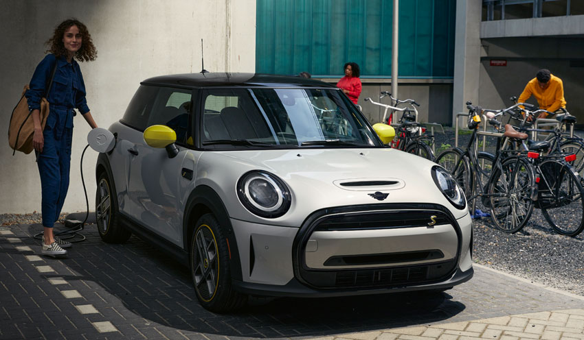 Someone charging their 2022 MINI Electric Hardtop 2 Door while parked downtown.