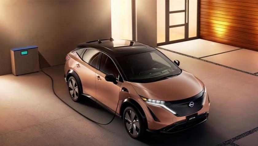 Nissan ARIYA plugged-in and charging outside a home