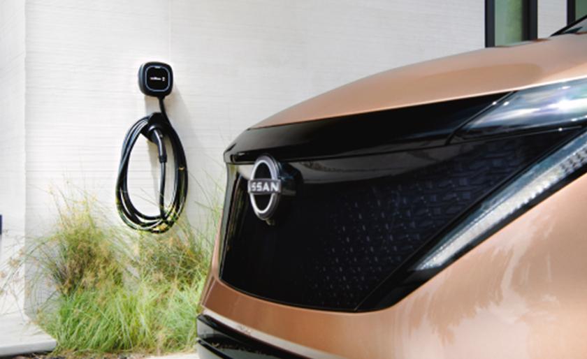 Zoomed-in shot of Nissan ARIYA near a charging cable, not plugged in.