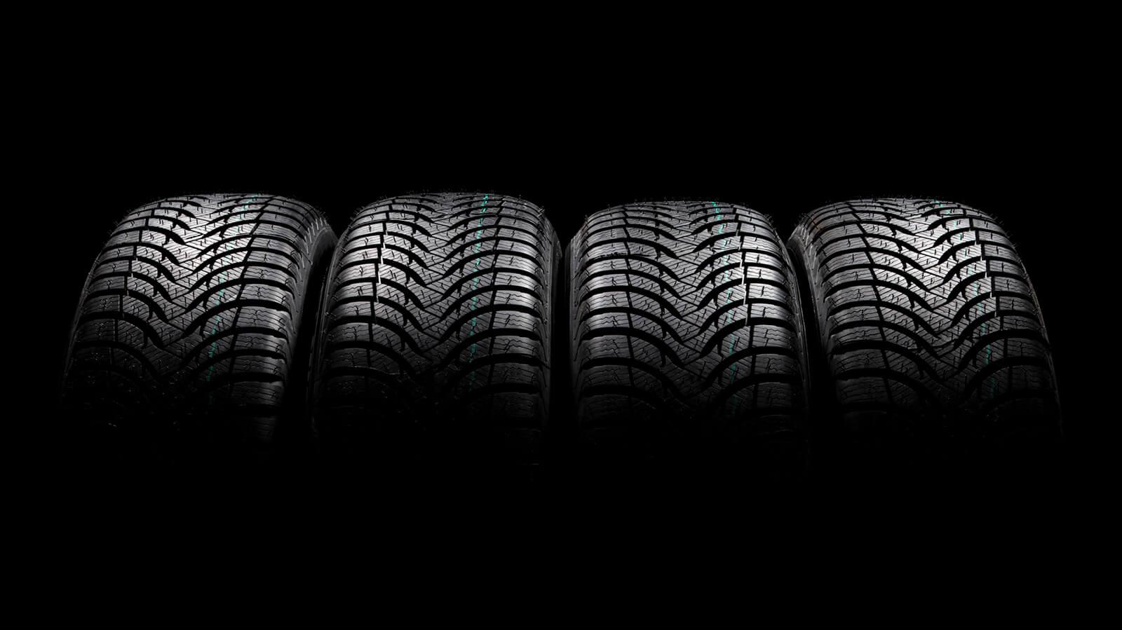 A row of vehicle tires on a dark background