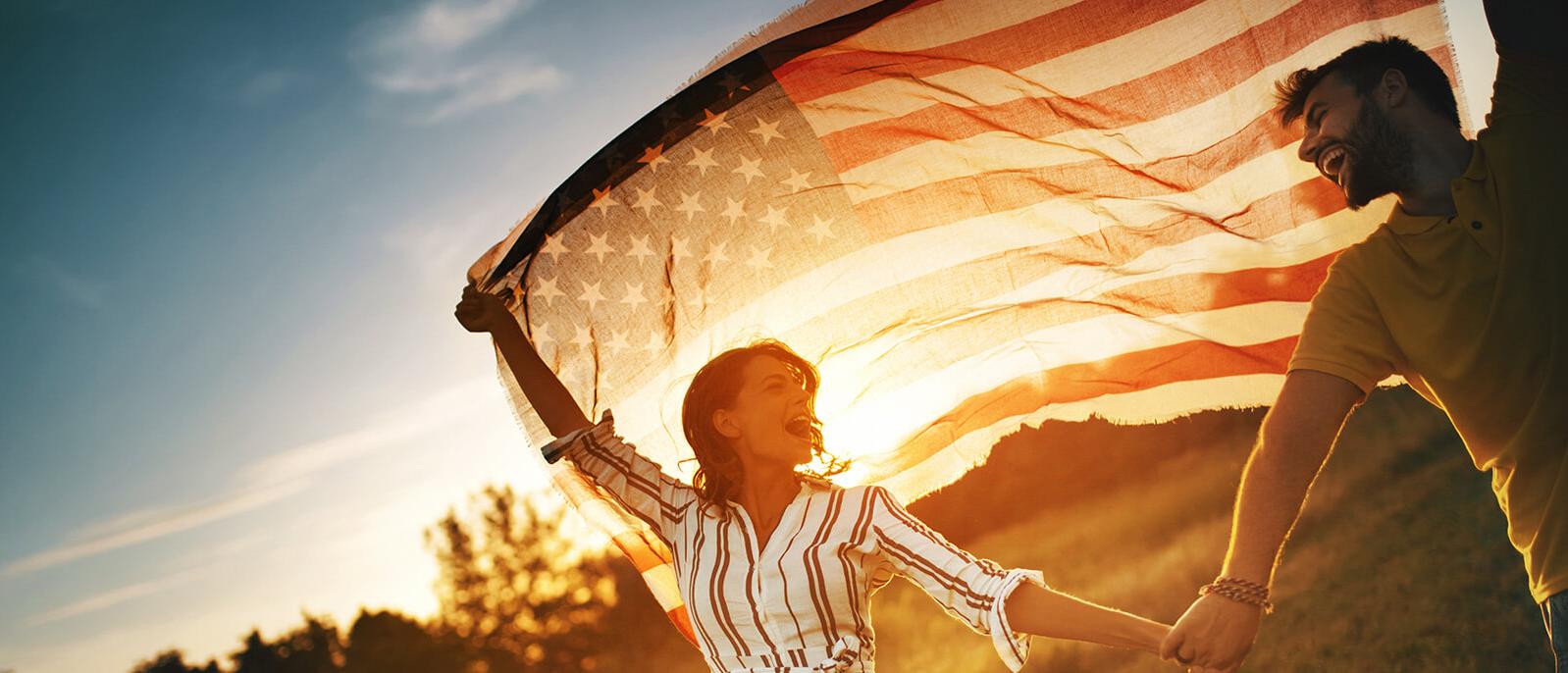 Smiling couple holding up an American flag