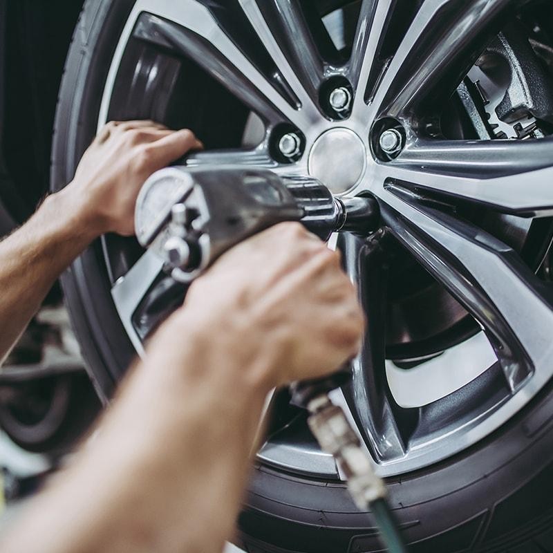 Mechanic's hands repairing a vehicle wheel