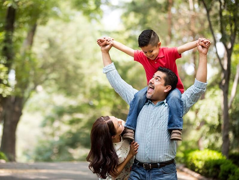 Smiling couple with their young son in a park