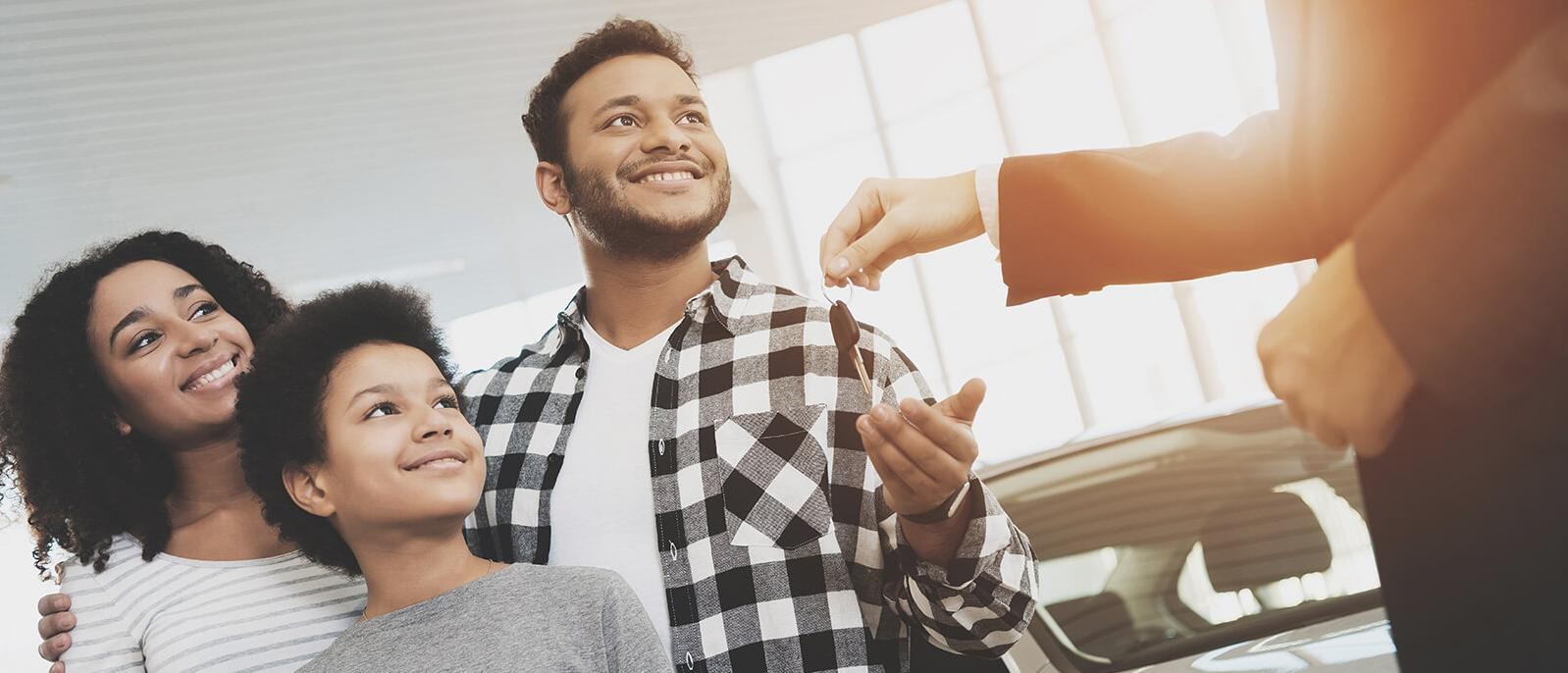 Family at a dealership getting their new car keys