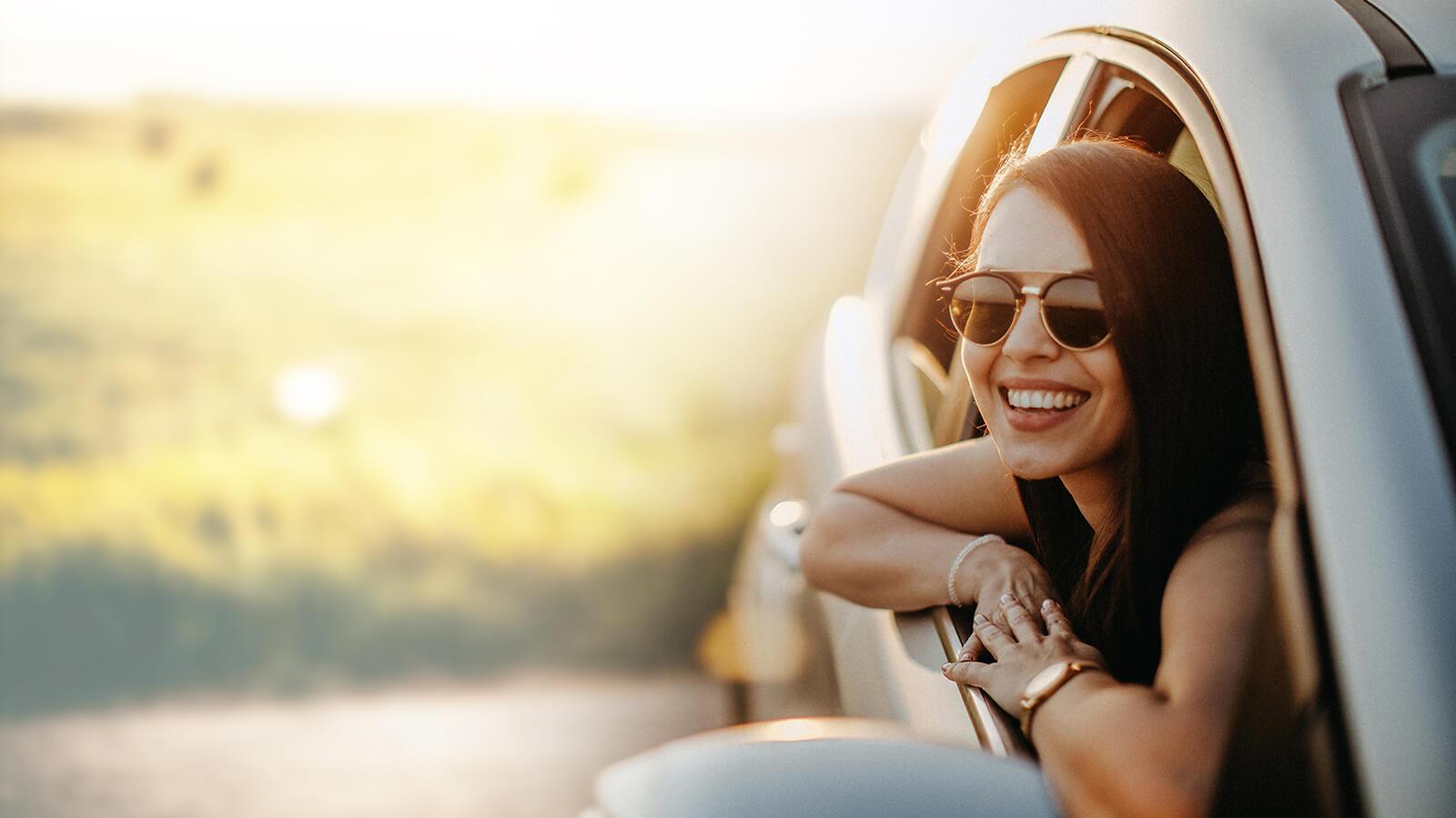 Smiling woman wearing sunglasses in a car